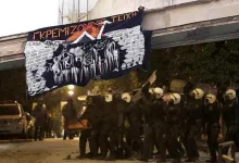A banner that says "We tear down walls" with the sign of squats, is hanging over the heads of cops who are trying to raid the building during the eviction of 2020.